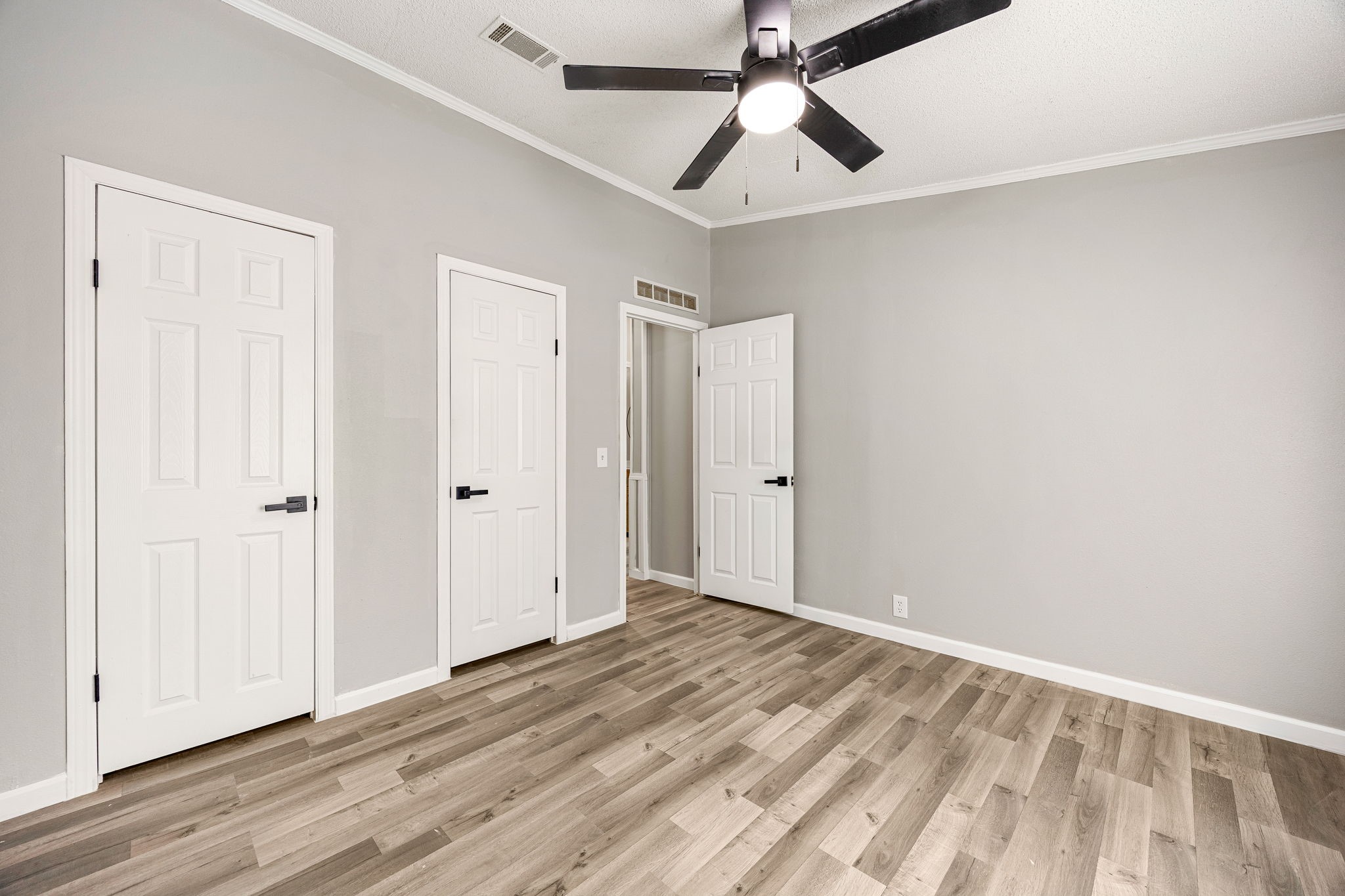14262 Shadow Bay Drive Willis, TX 77318 - Photo 18 of 26 an empty room with wooden floor ceiling fan and windows