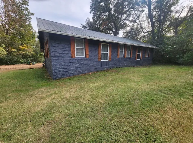 a large white kitchen with a sink and dishwasher a stove top oven with wooden floor