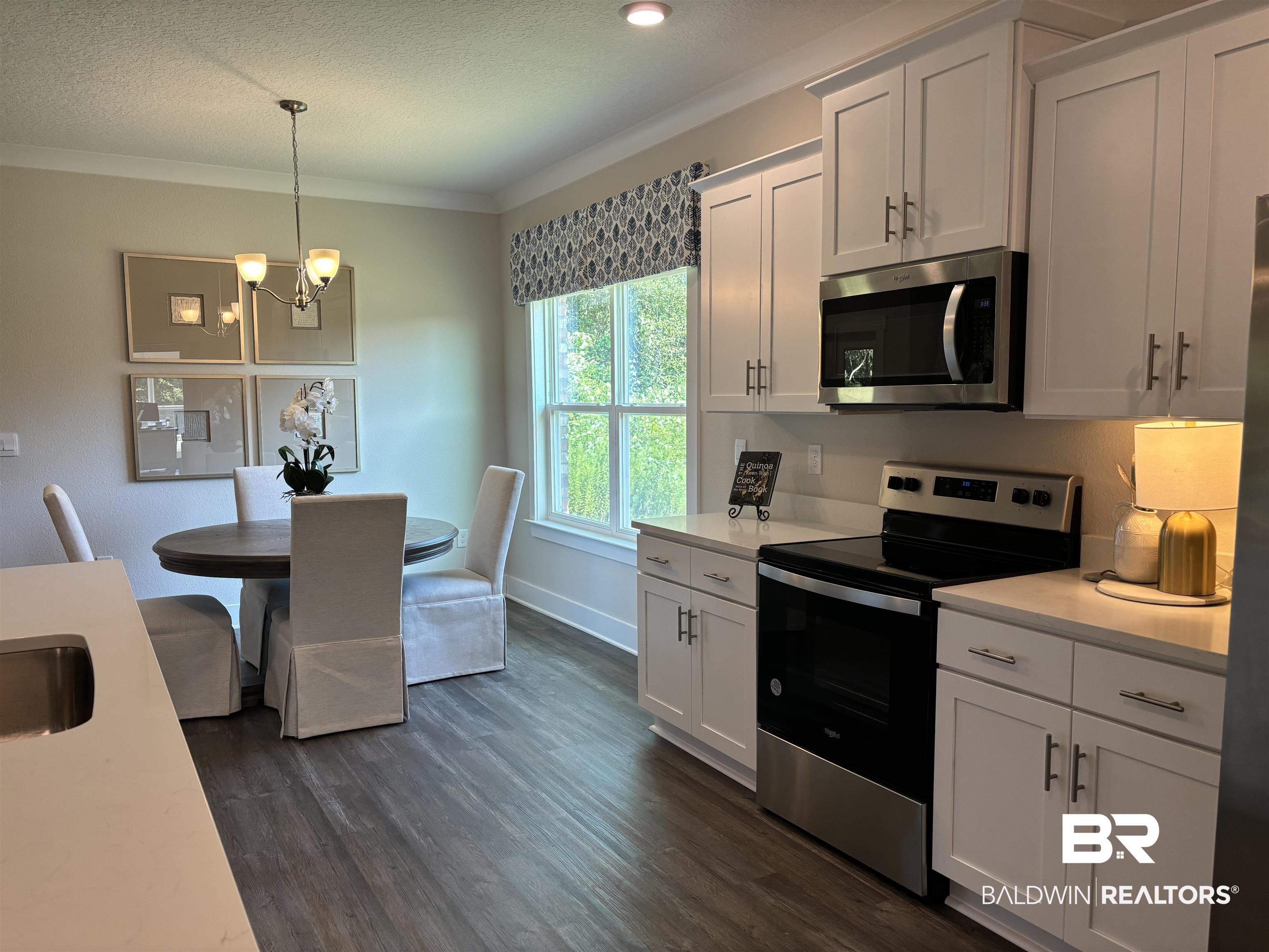 370 Barndling Street Fairhope, AL 36532 - Photo 11 of 30 Kitchen featuring dark hardwood / wood-style flooring, a notable chandelier, white cabinets, and stainless steel appliances