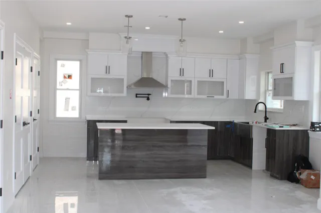 a kitchen with kitchen island a sink stainless steel appliances and cabinets