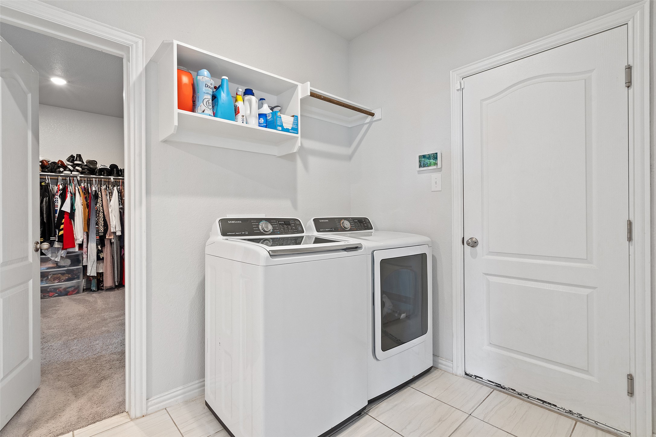 4101 Gildas Path Pflugerville, TX 78660 - Photo 14 of 16 Laundry room (downstairs off the primary closet) with independent washer and dryer and light tile patterned floors
