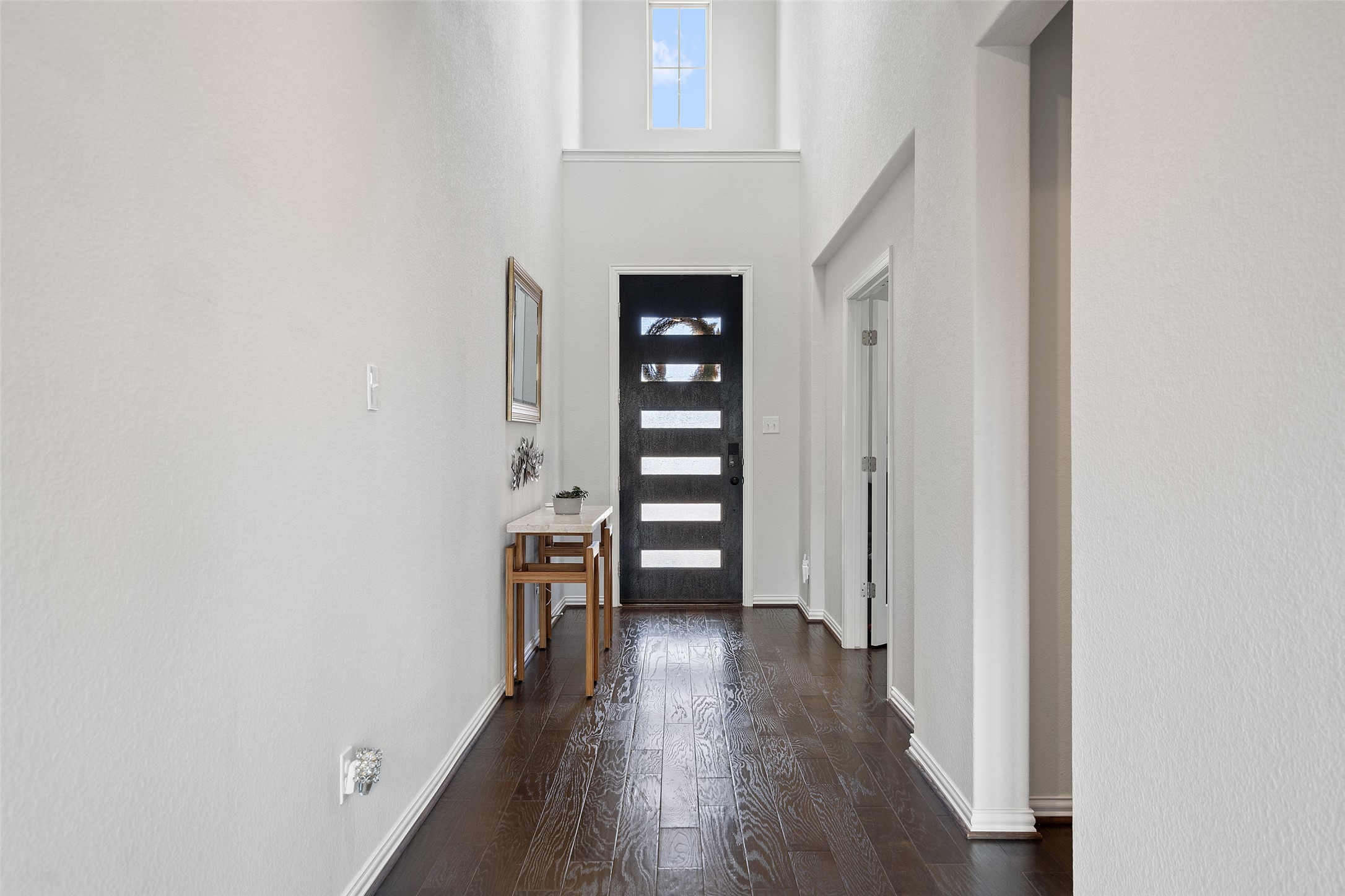 4101 Gildas Path Pflugerville, TX 78660 - Photo 2 of 16 Entryway with dark wood-style floors and a high ceiling with stunning chandelier