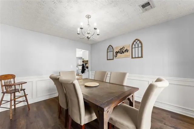 a view of a dining room with furniture wooden floor and a chandelier