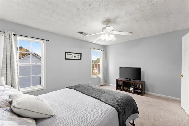 a bedroom with a bed desk and a window