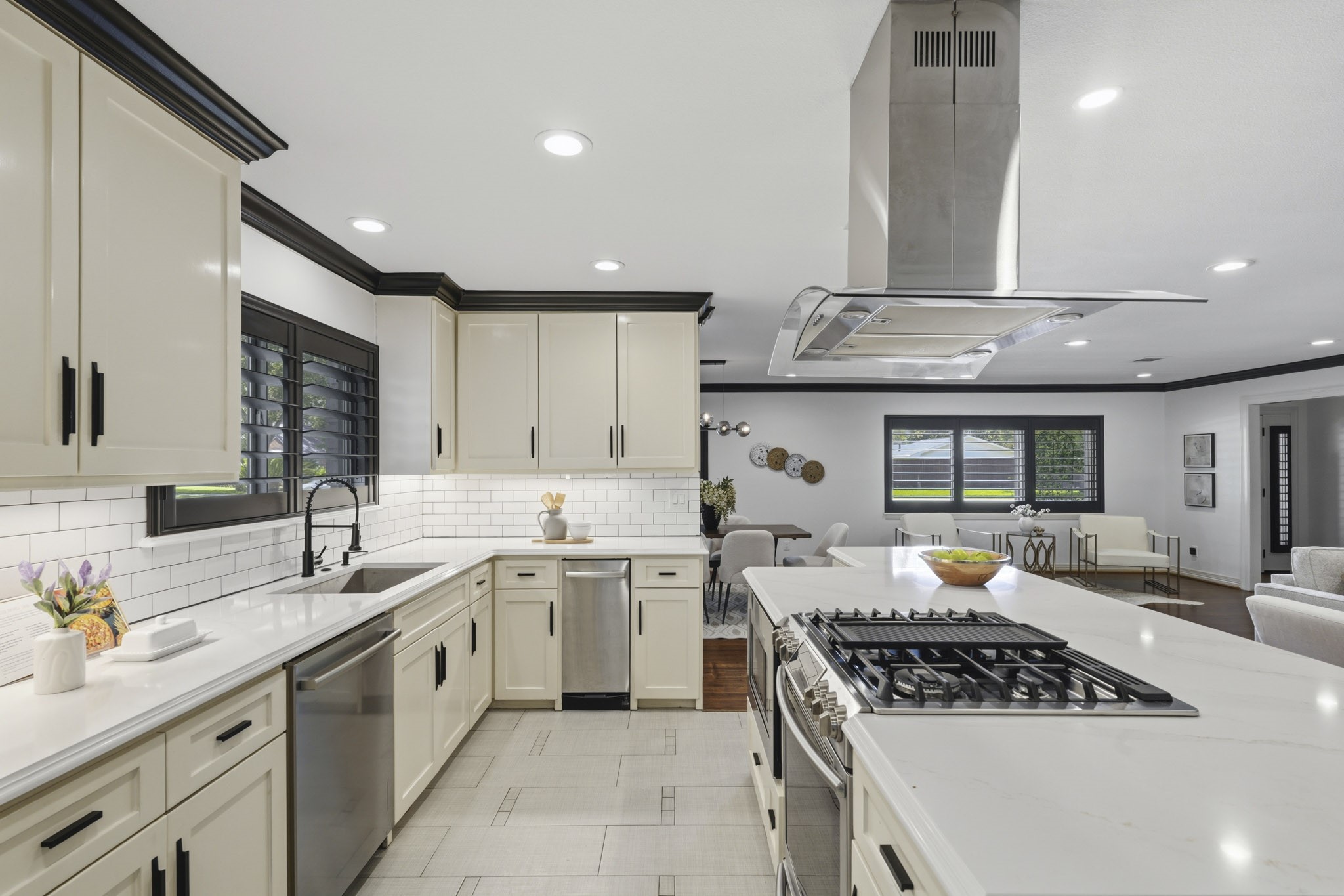 2302 Chimney Rock Road Houston, TX 77056 - Photo 9 of 28 Beautiful timeless designed kitchen with quartz countertops, gas stove top, stainless steel appliances, trash compact system, under-mount cabinet lighting, LED recessed lighting, stately crown molding, and fresh paint throughout.
