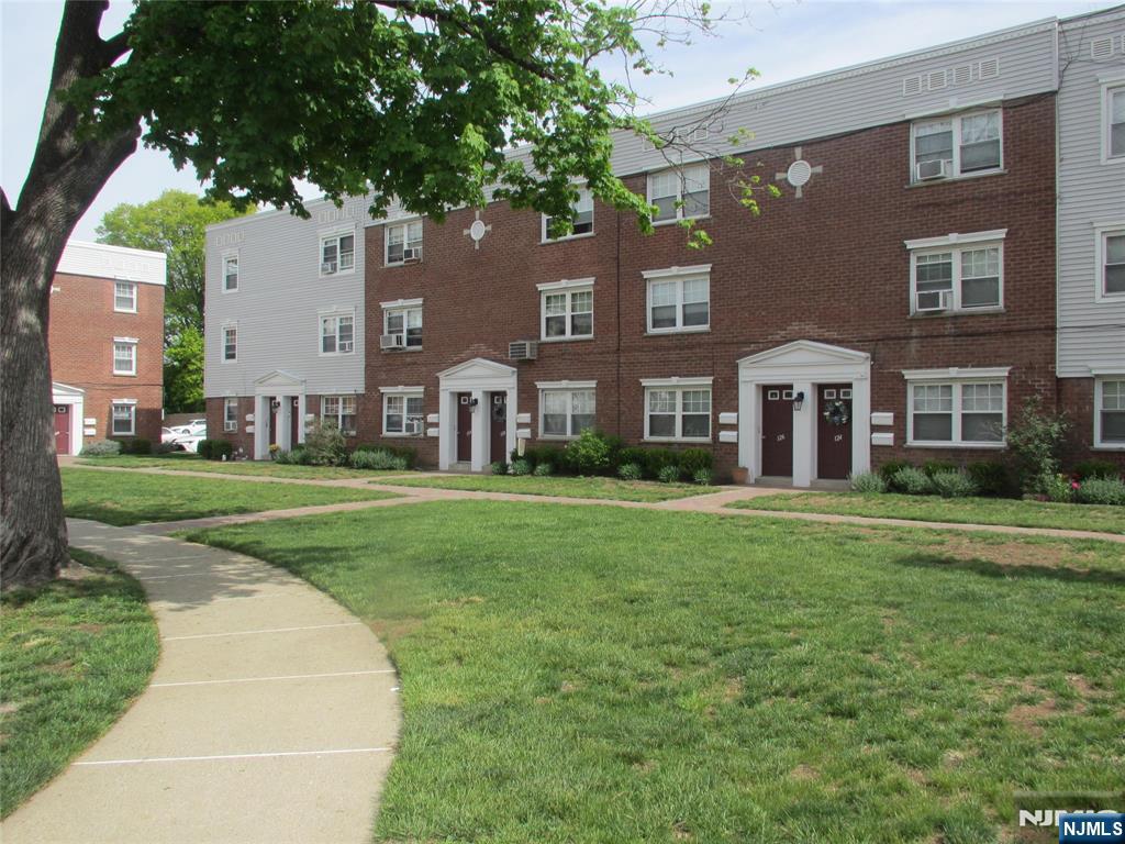126 Hastings Avenue, Unit A Rutherford, NJ 07070 - Photo 2 of 11 a view of a house with a big yard and large trees
