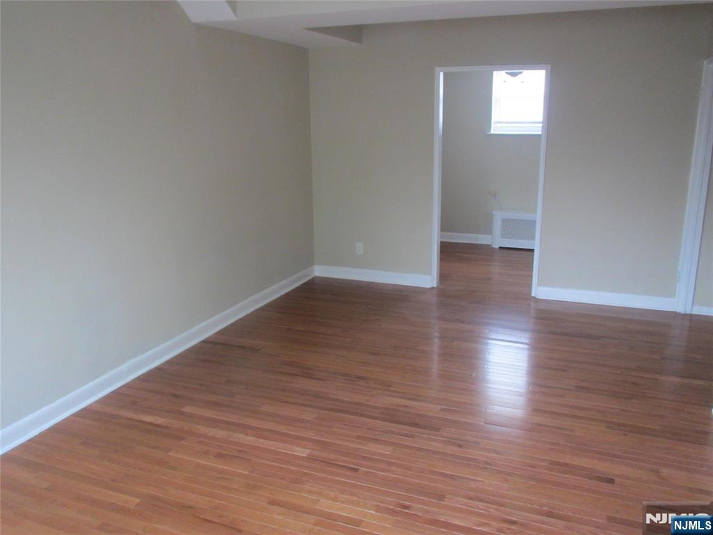 126 Hastings Avenue, Unit A Rutherford, NJ 07070 - Photo 3 of 11 a view of an empty room with wooden floor and a window