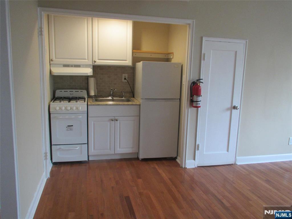 126 Hastings Avenue, Unit A Rutherford, NJ 07070 - Photo 5 of 11 a kitchen with a refrigerator sink and cabinets