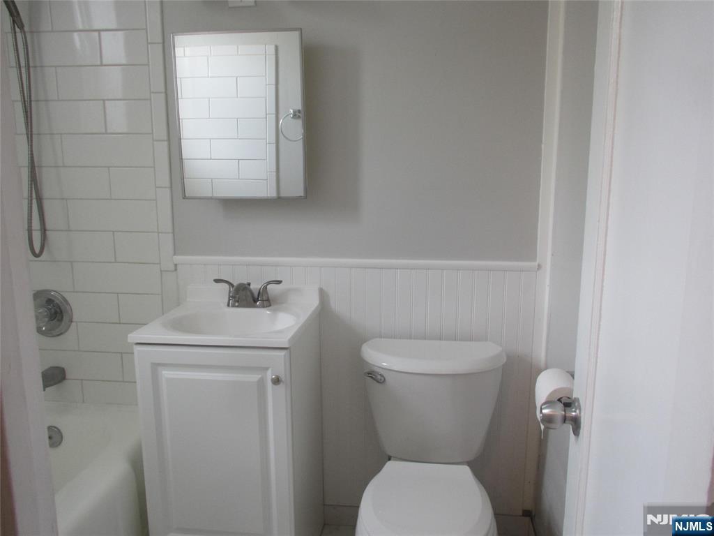 126 Hastings Avenue, Unit A Rutherford, NJ 07070 - Photo 10 of 11 a bathroom with a toilet sink and mirror