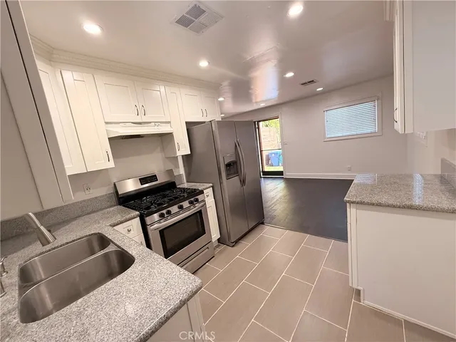a kitchen with granite countertop a stove and a refrigerator