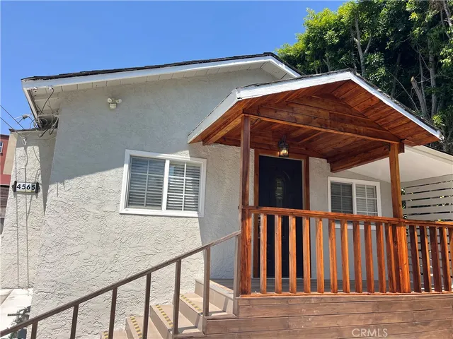 a view of wooden house with a small yard