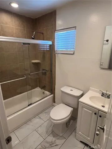 a white toilet sitting next to a bathroom sink and tub
