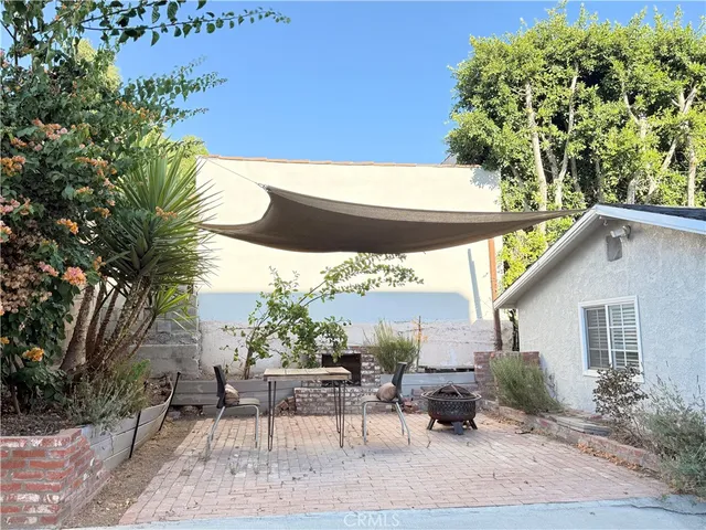 a backyard of a house with table and chairs