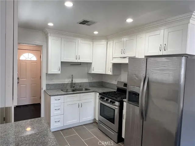a kitchen with a refrigerator sink and cabinets