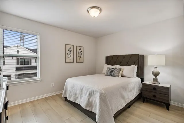 a bedroom with a bed and wooden floor