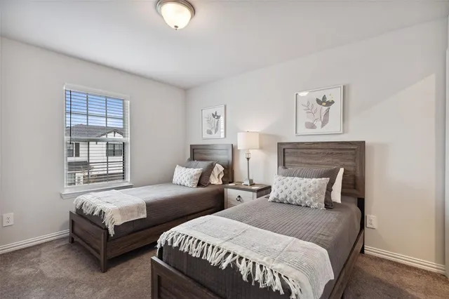 a bedroom with two beds and a window