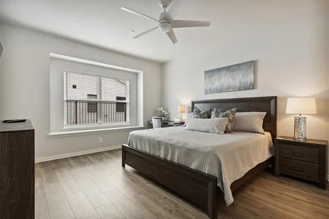 a spacious bedroom with a bed and wooden floor