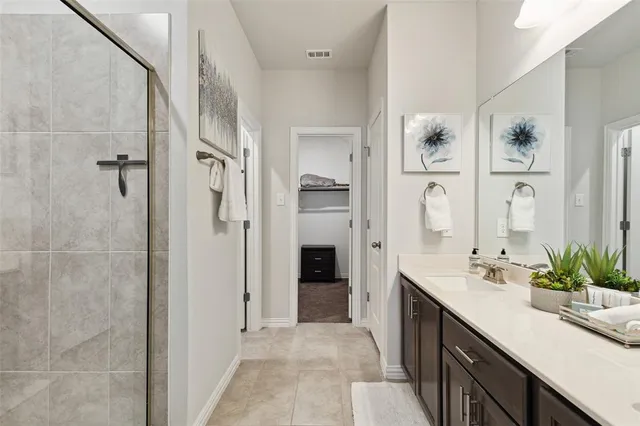 a bathroom with a double vanity sink a large mirror and a shower
