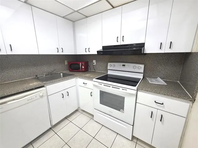 a kitchen with white cabinets and white appliances
