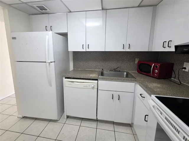 a white refrigerator freezer sitting inside of a kitchen