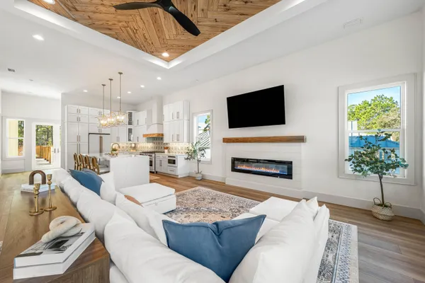 a kitchen with stainless steel appliances kitchen island granite countertop a dining table chairs and white cabinets