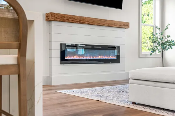 a stove top oven sitting inside of a kitchen with stainless steel appliances wooden floor