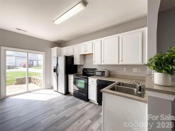 a kitchen with granite countertop a refrigerator sink and stove top oven
