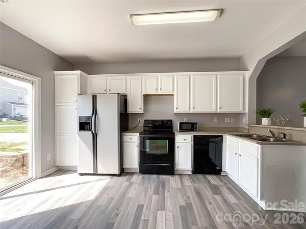 a kitchen with granite countertop a stove top oven and refrigerator