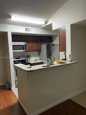 a kitchen with stainless steel appliances a sink stove and cabinets