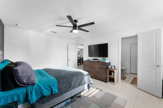 a bedroom with a bed a mirror and a flat screen tv