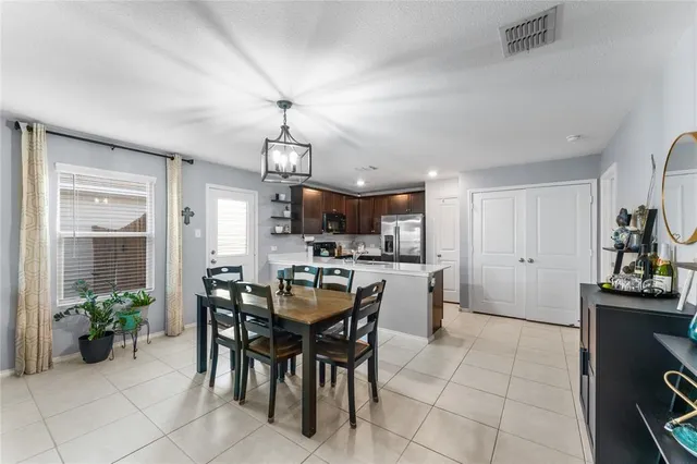 a view of a dining room and livingroom with furniture wooden floor a chandelier