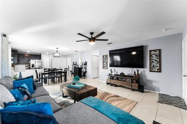 a living room with furniture kitchen view and a window