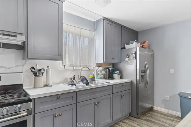 a kitchen with stainless steel appliances a sink stove and refrigerator
