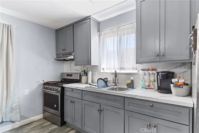 a kitchen with stainless steel appliances granite countertop a sink a stove and cabinets