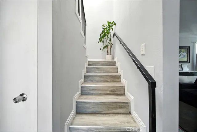 a view of staircase with white walls and a potted plant