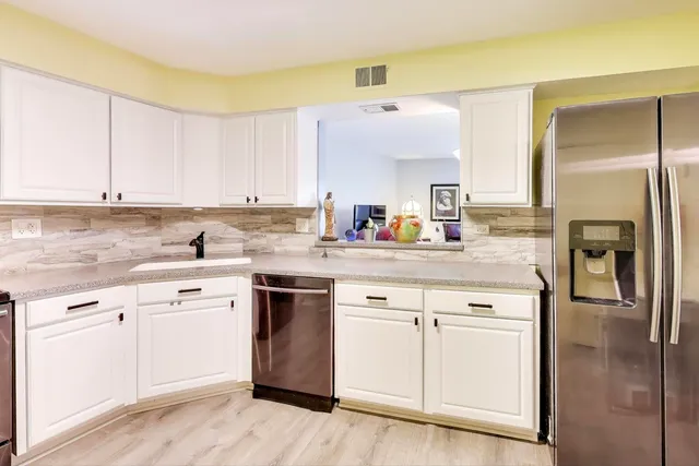 a kitchen with stainless steel appliances white cabinets and a refrigerator