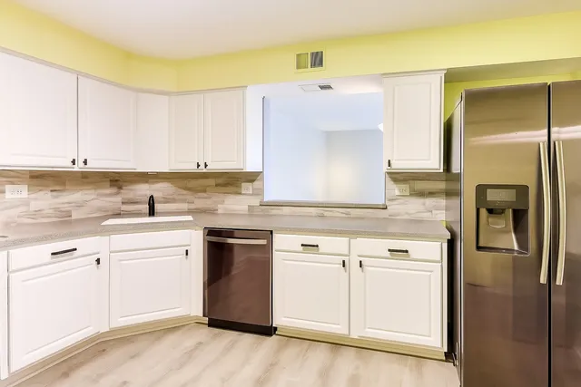 a kitchen with stainless steel appliances granite countertop a refrigerator a stove top oven a sink and dishwasher