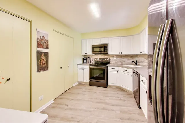 a kitchen with stainless steel appliances a stove a sink and a refrigerator