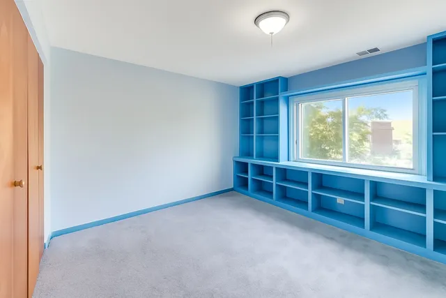 a bed room with a bed and a painting on the wall