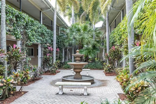 a view of a house with a fountain and plants