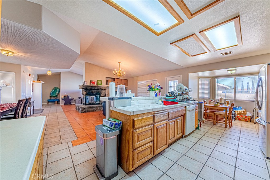 9922 Phelan Road Oak Hills, CA 92344 - Photo 11 of 30 a kitchen with stainless steel appliances granite countertop a barbecue grill and large cabinets