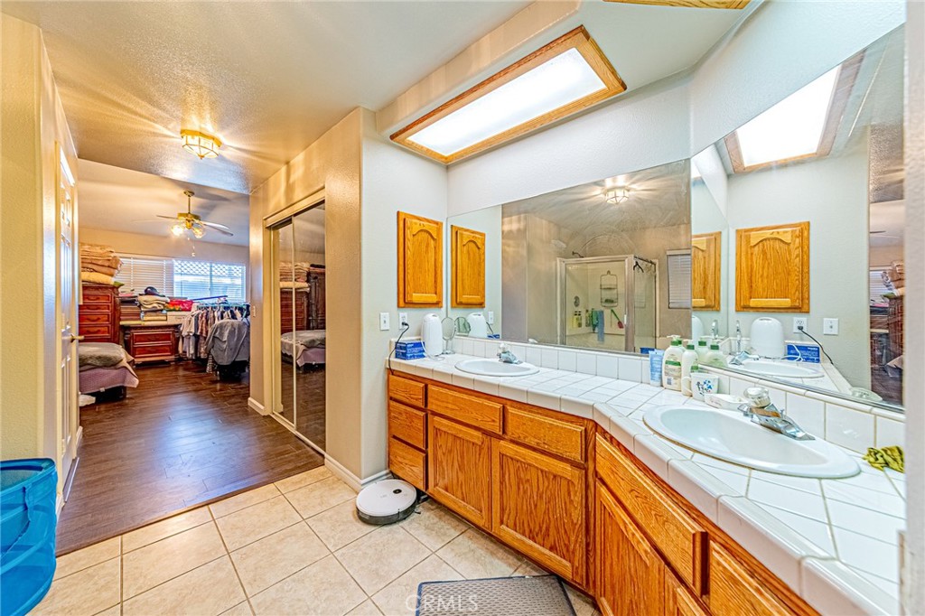 9922 Phelan Road Oak Hills, CA 92344 - Photo 14 of 30 a spacious bathroom with a sink a mirror and next to a window