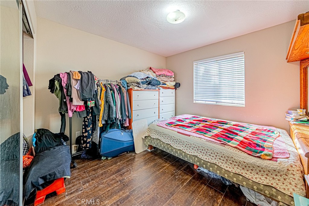 9922 Phelan Road Oak Hills, CA 92344 - Photo 16 of 30 a bedroom with bed and a large mirror