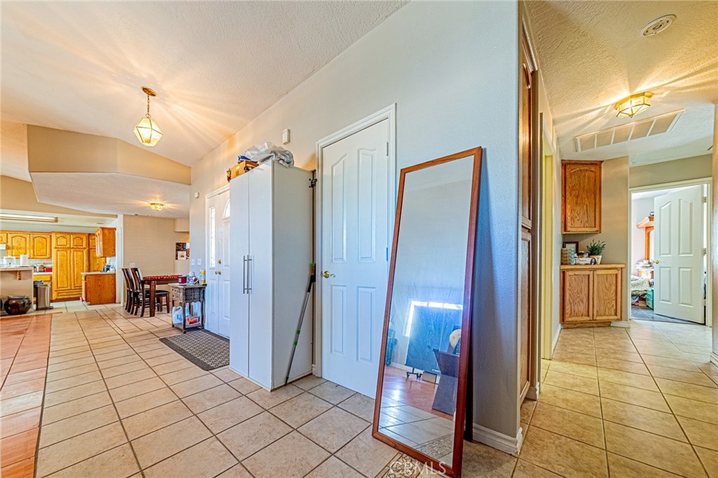 9922 Phelan Road Oak Hills, CA 92344 - Photo 9 of 30 a view of a hallway with dining area and chandelier
