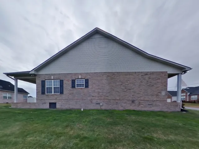 a backyard of a house with table and chairs