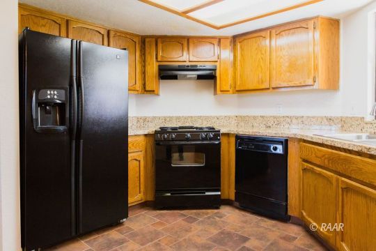 1114 North Inyo Street Ridgecrest, CA 93555 - Photo 13 of 31 a kitchen with granite countertop stainless steel appliances and wooden cabinets