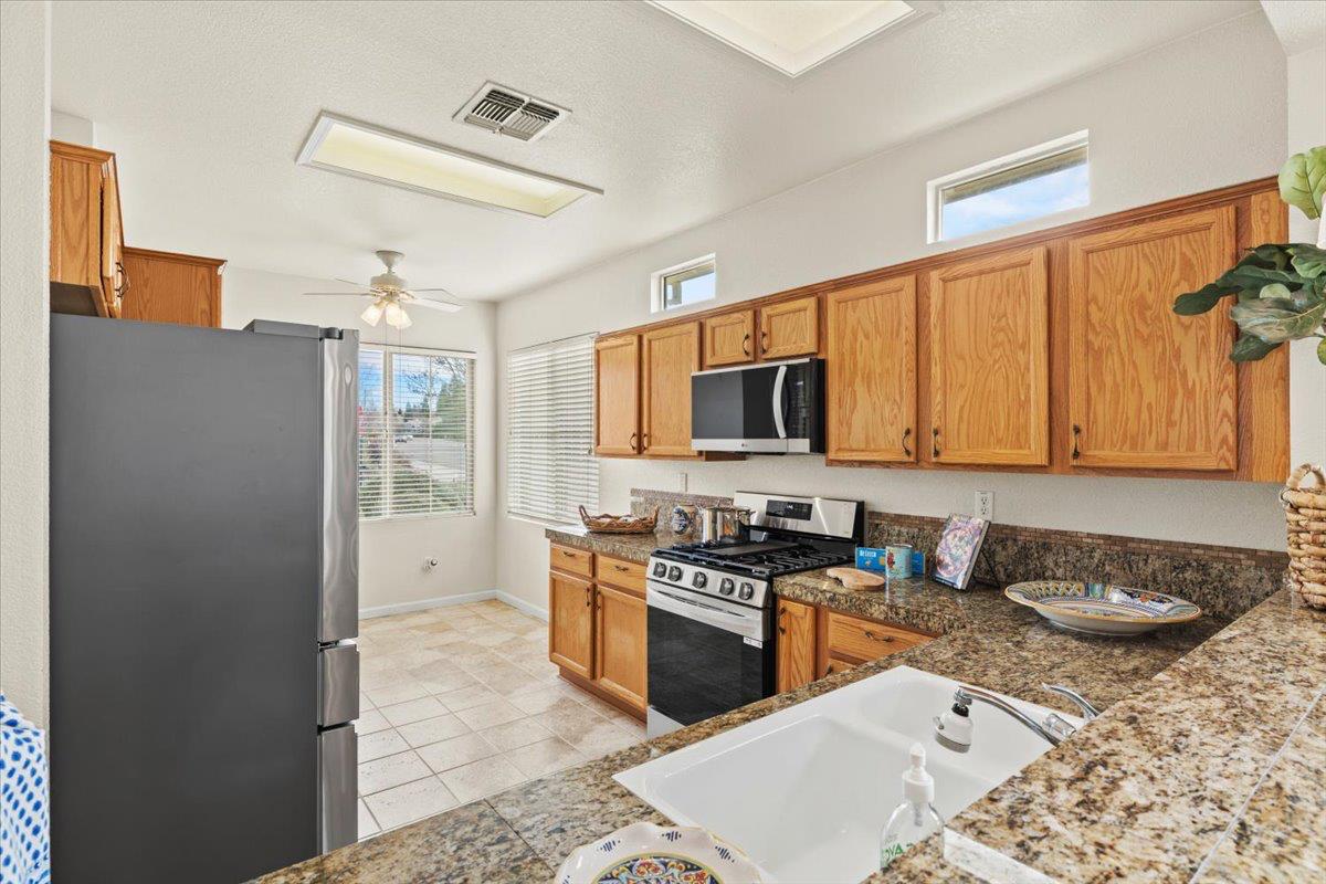 596 Geary Lane Lincoln, CA 95648 - Photo 6 of 27 a kitchen with stainless steel appliances granite countertop a stove a sink and a refrigerator