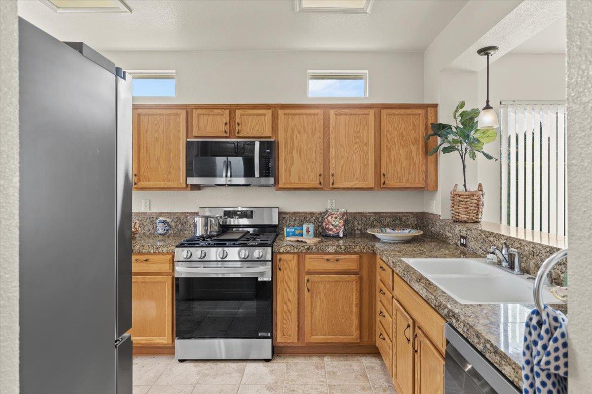 596 Geary Lane Lincoln, CA 95648 - Photo 7 of 27 a kitchen with a sink stove and microwave