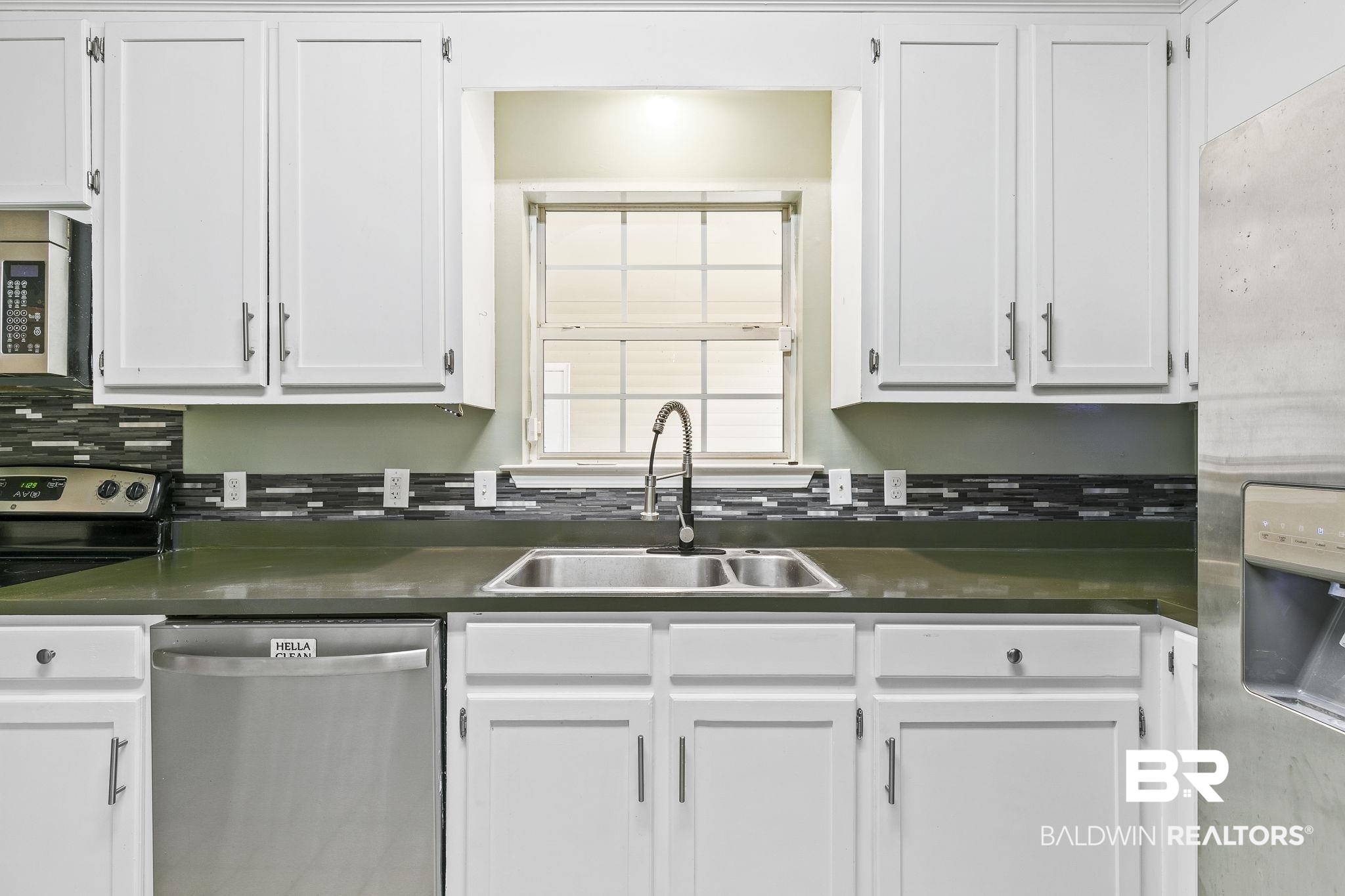 474 Ridgewood Drive Daphne, AL 36526 - Photo 22 of 57 Kitchen with backsplash, sink, appliances with stainless steel finishes, and white cabinetry