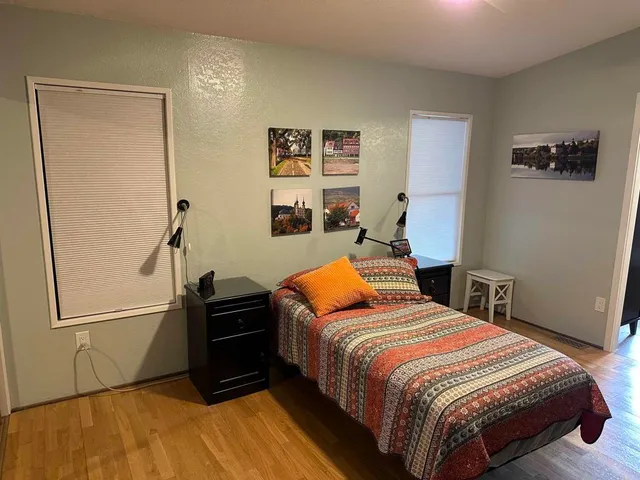 a bedroom with a bed and wooden floor
